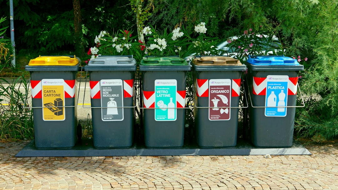 a-row-of-trash-cans-sitting-on-top-of-a-sidewalk-7m2ljcw6phi