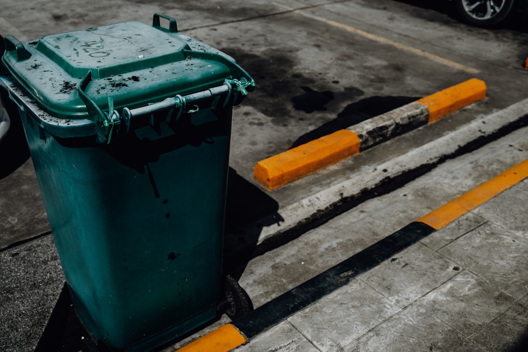 trash-can-and-parking-bumpers-on-pavement-rkbodtztg9s
